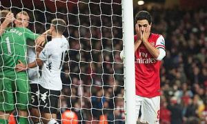Arsenal's Mikel Arteta holds his head in his hands after he misses penalty against Fulham.